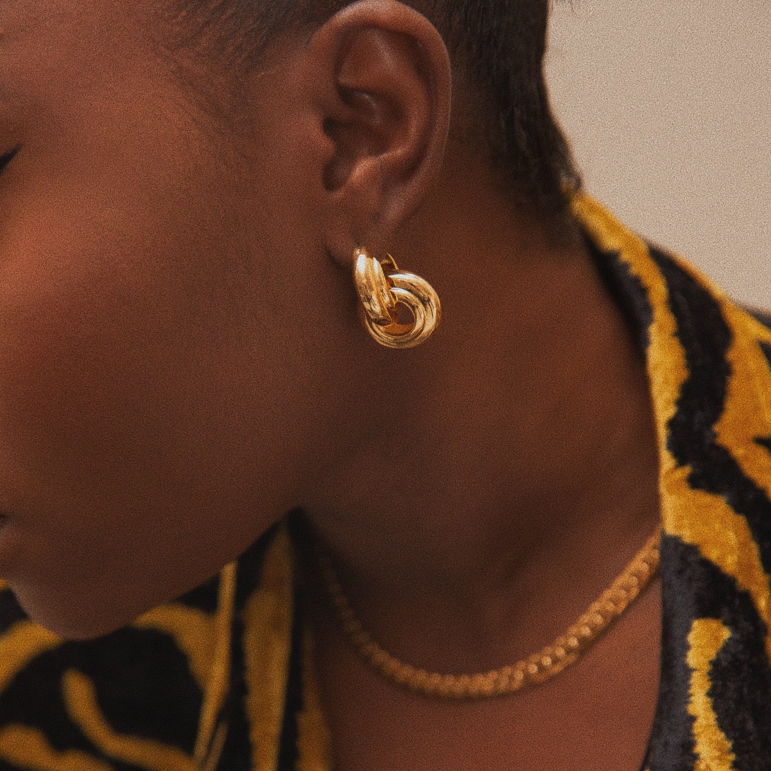 Fisayo Longe in the Anisa Sojka Gold Interlocking Hoop Earrings and Gold Compact Link Necklace